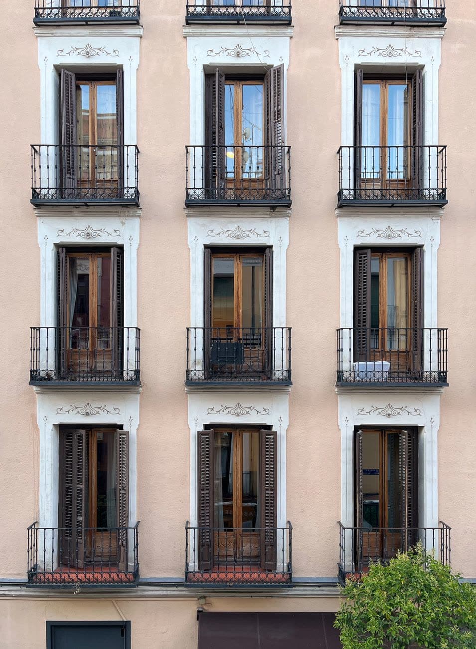 Fachada clásica de un edificio de viviendas con balcones y contraventanas de madera