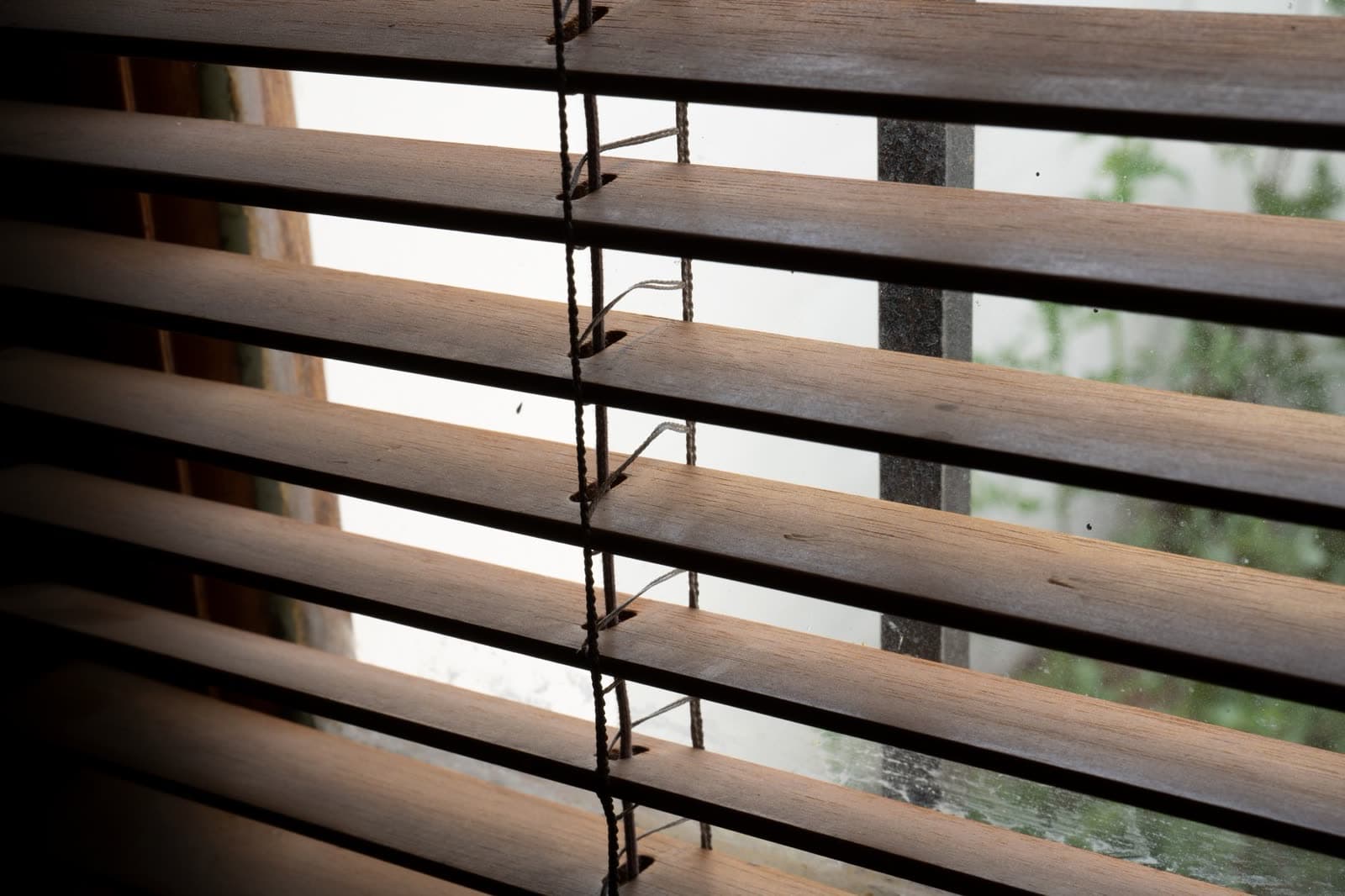Persiana veneciana de lamas de madera vista a contraluz desde dentro