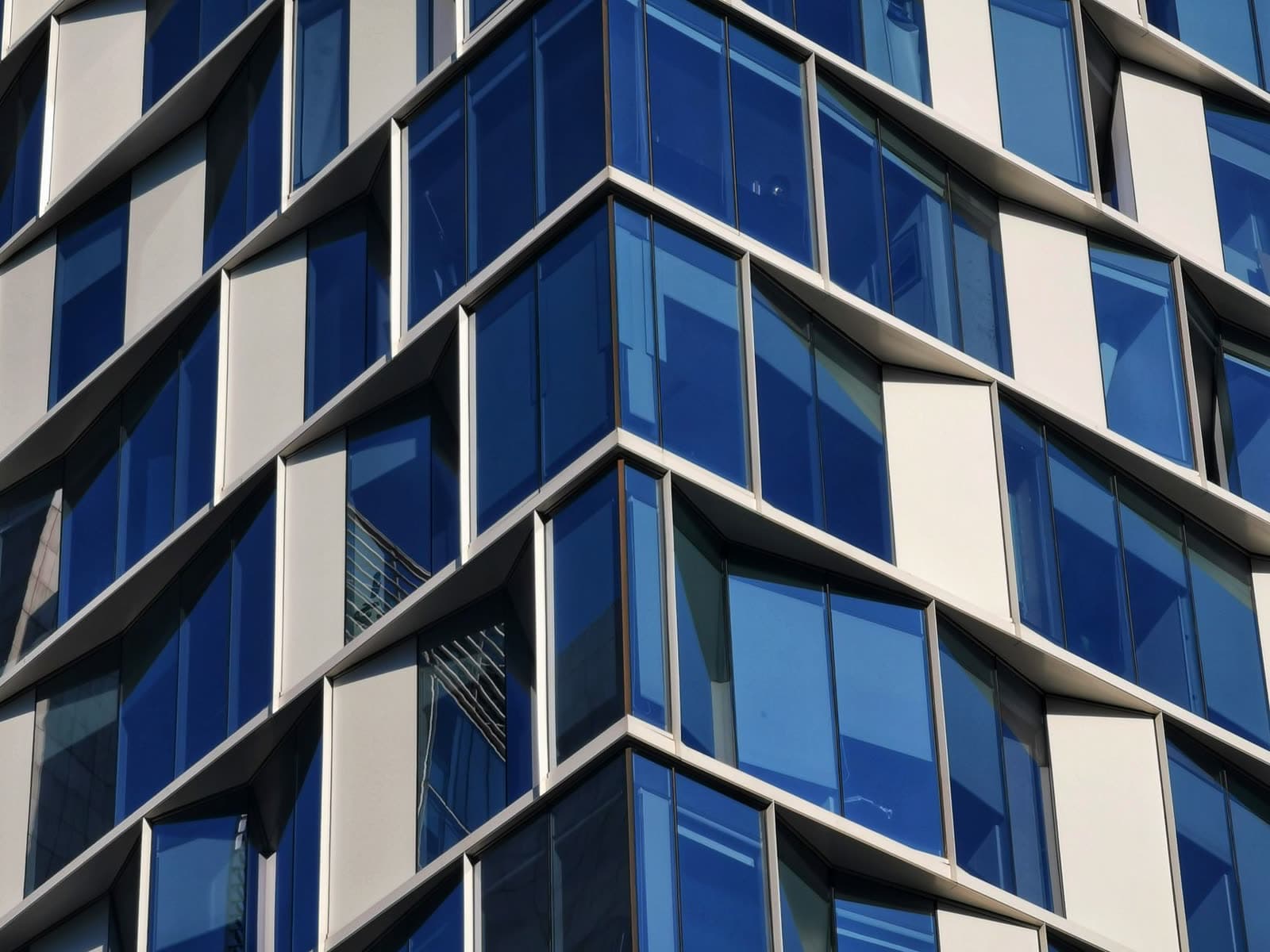 Fachada acristalada azul de un edificio moderno vista en esquina